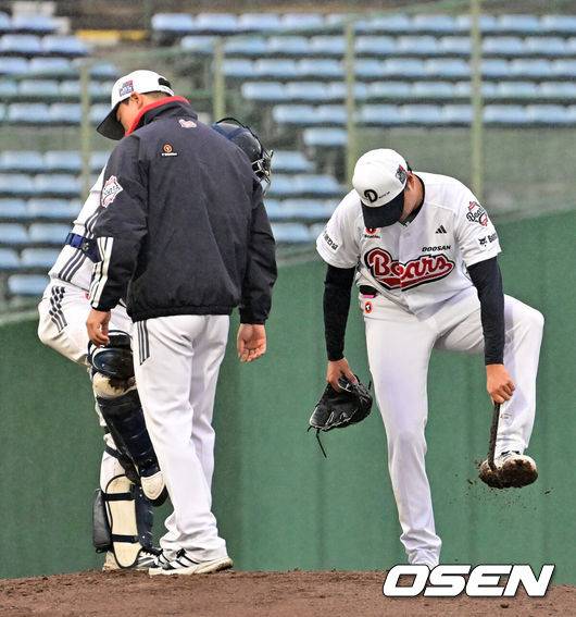 [OSEN=미야자키(일본), 지형준 기자] 26일 일본 미야자키 산마린 스타디움에서 두산 베어스와 롯데 자이언츠의 구춘대회 경기가 열렸다.두 팀의 맞대결은 롯데가 6-2로 앞선 3회말 악천후로 인해 노게임 선언됐다.&nbsp;3회초 두산 이영하가 계속 내리는 비에 스파이크에 묻은 흙을 털어내고 있다. 2026.02.26 /jpnews@osen.co.kr