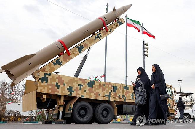 지난 11일 이란 수도 테헤란에서 탄도미사일 이동발사대 옆을 걷는 여성들 [AFP 연합뉴스 자료사진. 재판매 및 DB 금지]