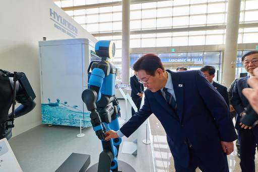 이재명 대통령이 27일 전북 군산새만금컨벤션센터에서 열린 새만금 로봇·수소·AI 시티 투자협약식에 앞서 전시된 아틀라스 로봇을 살펴보고 있다. /연합뉴스 제공