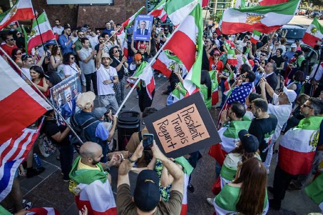 28일(현지시간) 로스앤젤레스에서 이란 커뮤니티 구성원들과 함께 미국과 1979년 이슬람 혁명 이전 이란 국기를 흔들며 춤을 추고 있다. (사진=AFP)