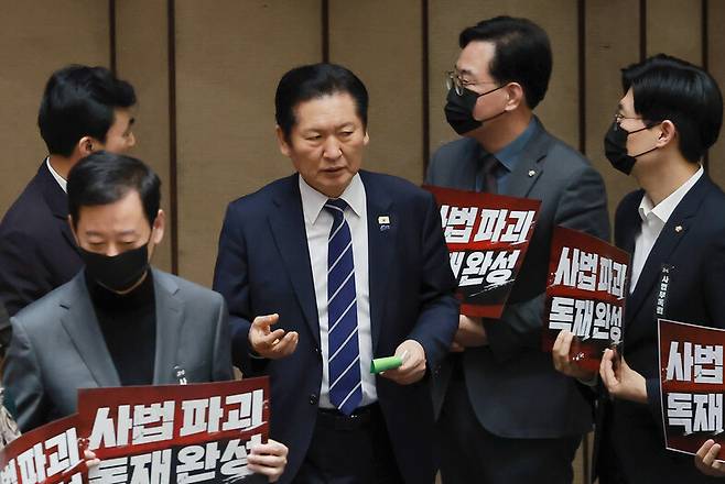 정청래 더불어민주당 대표가 28일 국회에서 열린 2월 임시국회 8차 본회의에서 전날 상정된 법원조직법 개정안(대법관 증원법)에 대한 무제한 토론 종결 동의의 건 투표를 하고 있다. 정 대표 주위에서 국민의힘 송언석 원내대표 등 의원들이 사법3법(법왜곡죄·재판소원제·대법관 증원) 규탄 시위를 하고 있다. 연합뉴스