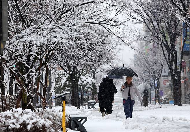 지난 16일 많은 눈이 내린 강원 강릉시 교동 솔올택지에서 주민들이 조심스럽게 걸어가고 있다. 연합뉴스