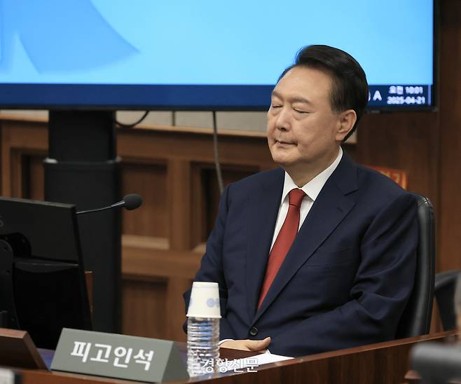 윤석열 전 대통령이 지난해 4월 21일 서울중앙지법에서 열린 내란 사건 재판 법정의 피고인석에 앉아 눈을 감고 있다. 이준헌 기자