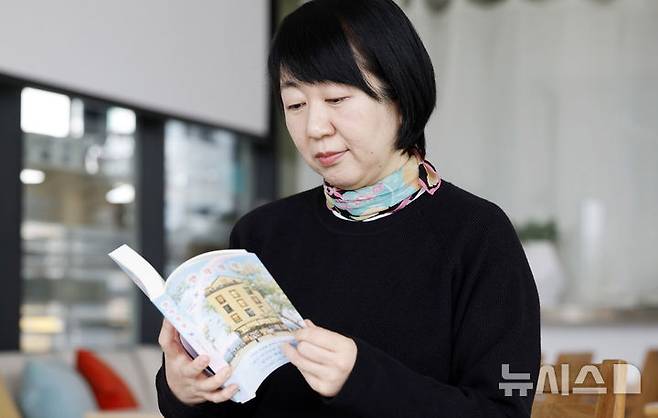 [인천=뉴시스] 김혜진 기자 = 조경아 작가가 지난달 27일 인천 중구 카페 마숑에서 뉴시스와 인터뷰에 앞서 책을 보고 있다. 2026.03.01. jini@newsis.com