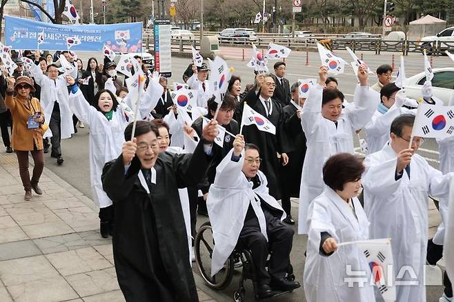 [부천=뉴시스] 조용익 경기 부천시장과 시민들이 1일 태극기를 들고 시청 앞 도심을 걷는 '만세운동 거리행진'에 참여하고 있다. (사진=부천시 제공) 2026.03.01. photo@newsis.com