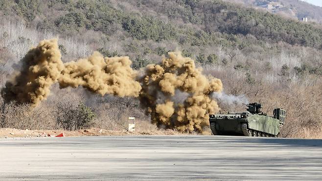 육군이 26일 양평종합훈련장에서 AI 기반 유·무인복합 한국형공병전투차량(K-CEV)의 첫 실전 훈련 현장을 공개했다. 사진은 K-CEV가 연막을 터뜨리고 사격하는 모습. 육군 제공