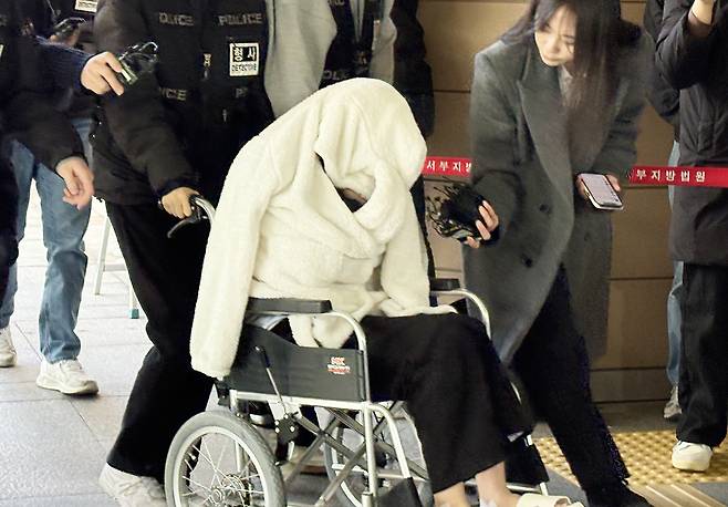 약물을 투약한 상태로 차량을 몰다 반포대교 난간을 뚫고 추락한 30대 여성이 지난달 27일 서울서부지법에서 열린 구속 전 피의자 심문(영장실질심사)에 휠체어를 타고 출석하고 있다. 뉴스1