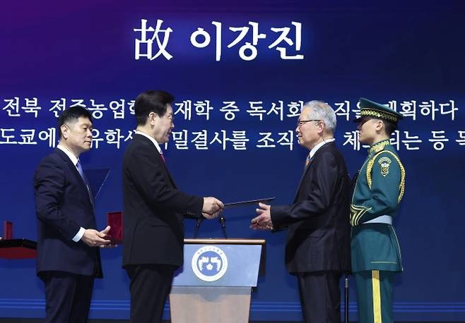 이재명 대통령, 3·1절 독립유공자 포상 - 이재명 대통령이 1일 서울 강남구 코엑스에서 열린 제107주년 3·1절 기념식에서 고 이강진 유공자의 외손자 황인성 씨에게 건국훈장 애족장을 수여하고 있다.   연합뉴스