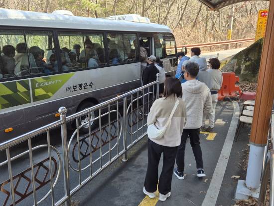 남해 금산을 오르내리는 마을버스가 복곡 제1주차장에서 제2주차장으로 올라가려는 승객을 태우고 있다.