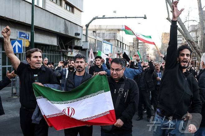 1일(현지시간) 이란 테헤란에서 미국과 이스라엘의 공습으로 암살된 이란 최고 지도자 아야톨라 알리 하메네이의 사진을 든 이란인들이 추모 집회에서 미국과 이스라엘을 규탄하는 구호를 외치고 있다. 2026.03.01. ⓒ AFP=뉴스1