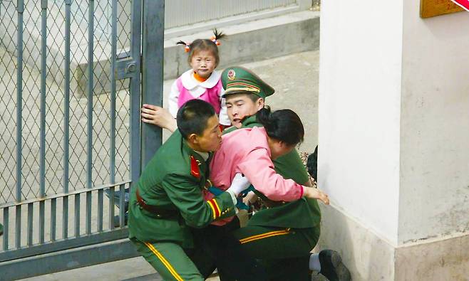 2002년 5월 중국 랴오닝성 선양 주재 일본 총영사관 앞에서 탈북자 장길수씨 가족이 일본 망명을 시도하며 공관 안으로 뛰어 들어가려 하자 중국 공안이 이를 가로막고 있다. 당시 함께 탈북한 가족은 17명에 달했으나, 이 가운데 최소 5명은 강제 북송된 것으로 추정된다./로이터 통신
