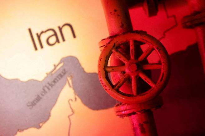 A map showing the Strait of Hormuz and Iran is seen behind a 3D printed oil pipeline in this illustration from June 22, 2025. [REUTERS/YONHAP]
