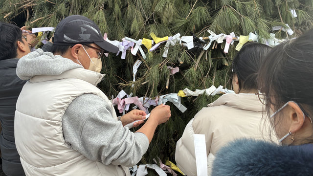 '금호강 정월대보름 축제' 행사에 참여한 주민들이 달집에 소원을 적은 쪽지를 걸고 있다. 서고은 수습기자