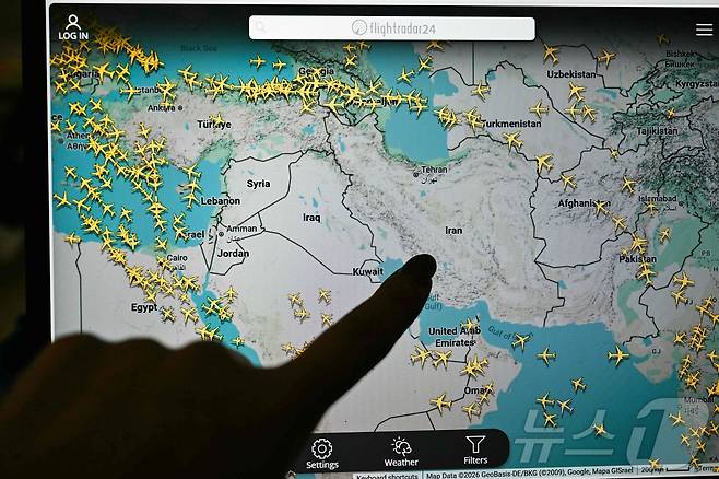 한 사람이 1일(현지시간) 플라이트레이더24(Flightradar24) 화면을 가리키고 있다. 2026.3.1 ⓒ AFP=뉴스1