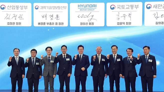 이재명 대통령이 27일 전북 군산 새만금컨벤션센터에서 열린 '새만금 로봇·수소·AI 시티 투자협약식'에서 참석자들과 기념촬영을 하고 있다.왼쪽부터 김용범 청와대 정책실장, 김성환 기후에너지환경부 장관, 김정관 산업부 장관, 배경훈 부총리 겸 과학기술정보통신부 장관, 이 대통령, 정의선 현대차그룹 회장, 김윤덕 국토교통부 장관, 김의겸 새만금개발청장, 김관영 전북도지사./연합뉴스