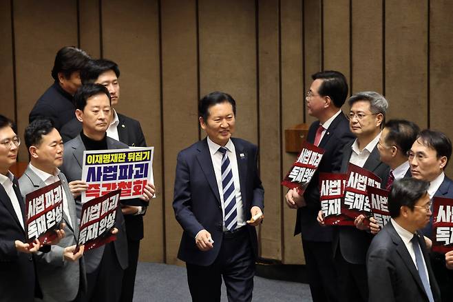 27일 서울 여의도 국회에서 열린 제432회 국회(임시회) 제8차 본회의에서 재판소원제 도입을 골자로 하는 헌법재판소법 일부개정법률안(대안)에 대한 무제한토론 종결 투표가 진행되는 가운데 정청래 더불어민주당 대표가 사법 3법과 관련 규탄 피켓 농성하는 국민의힘 의원들을 지나고 있다./뉴스1