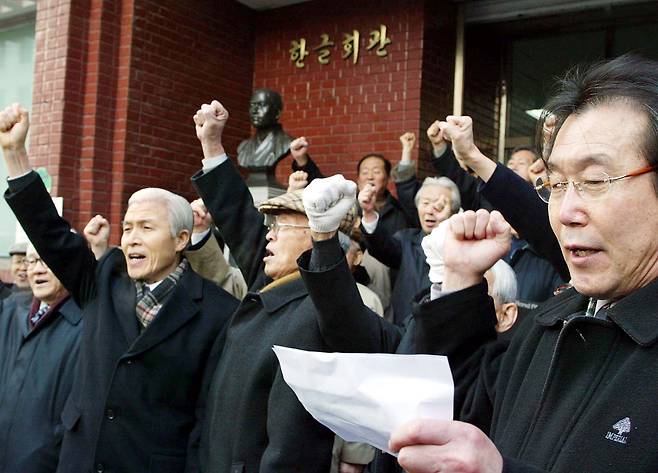Representatives of the Korean Language Society of Korea and related groups chant slogans during a protest outside the Hangeul Hall in Jongno District, central Seoul, on Jan. 26, 2005, opposing the Cultural Heritage Administration’s plan to replace the Gwanghwamun nameboard with a Chinese-character version. Lee Dae-ro, far right in front, leads the chants. [OH JONG-TAEK]