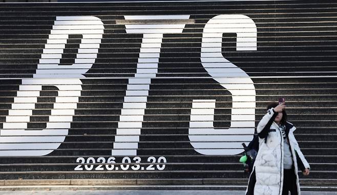 22일 오후 서울 종로구 세종문화회관 계단에 설치된 방탄소년단(BTS)의 정규 5집 컴백을 알리는 홍보물을 배경으로 관광객들이 기념촬영을 하고 있다. 서울시는 22일 광화문광장 자문단회의에서 BTS의 3년 9개월 만의 완전체 컴백공연인 'BTS 2026 Comeback Show @ Seoul'에 대해 조건부로 사용을 허가했다. /사진=뉴스1