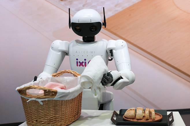 2일(현지시간) 스페인 바르셀로나 피라 그란 비아 전시장에서 열린 ‘월드모바일콩그레스(MWC26)’에서는 AI(인공지능)과 결합한 다양한 로봇과 IT기기들이 주목을 받았다. 사진 LG유플러스 부스에서 AI에이전트 ‘익시오가 그린 미래’를 주제로 로봇이 빨래를 옮기고 있는 모습.  [연합]