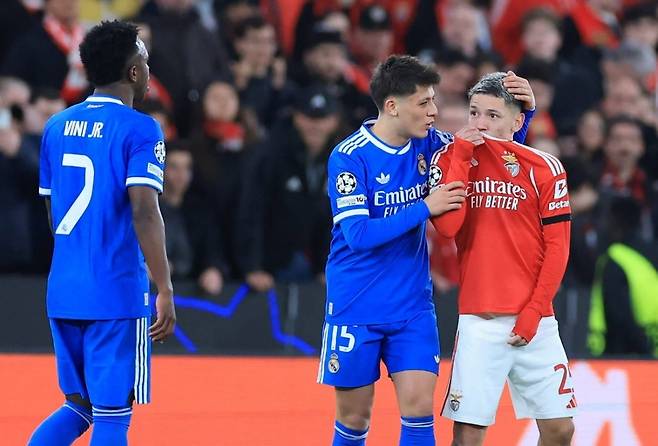 벤피카의 잔루카 프레스티아니(오른쪽)가 지난달 18일 포르투갈 리스본의 이스타디우 다 루스에서 열린 레알 마드리드와의 유럽축구연맹(UEFA) 챔피언스리그 녹아웃 라운드 플레이오프 1차전 홈경기 도중 유니폼으로 입을 가린 채 상대 팀 비니시우스(왼쪽)에게 말하고 있다. AFP연합뉴스