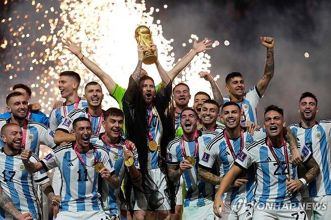 2022 카타르 월드컵 우승 트로피를 들어 올린 아르헨티나의 리오넬 메시(가운데). [AP=연합뉴스 자료사진]