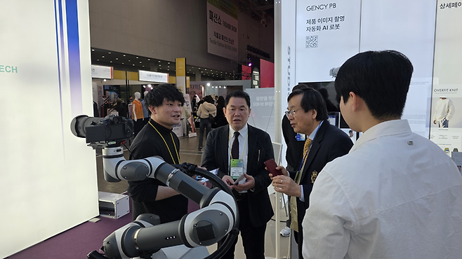 ▲ 대구국제섬유박람회에 참여한 내빈들이 인공지능(AI) 테크관에서 로봇 촬영 스튜디오 솔루션의 설명을 듣고 체험 중이다. 김산호 기자