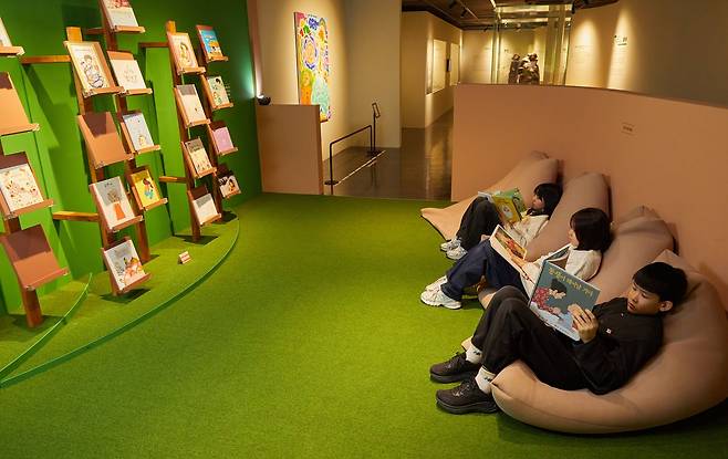 새 생명을 기다리고 맞이하는 순간들을 따뜻한 시선으로 조명한 ‘아가 마중’ 전시를 찾은 고가람 학생모델과 서지안·이주호 학생기자(왼쪽부터)가 임신·출생·가족 이야기를 담은 그림책들을 살펴봤다.