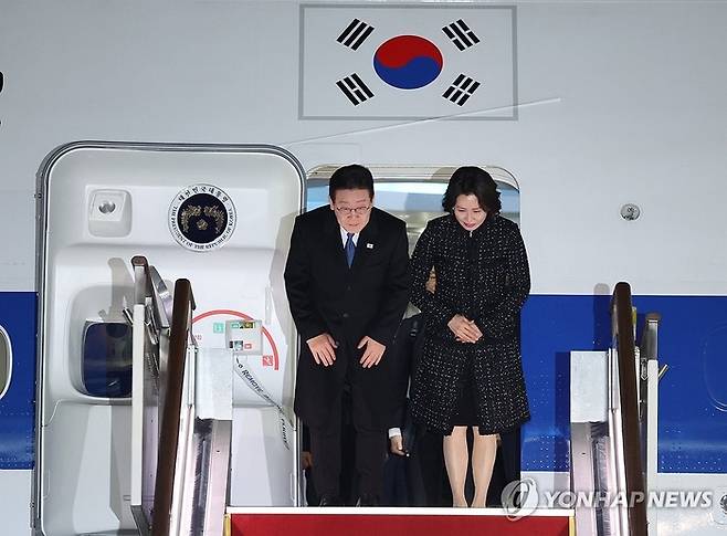 싱가포르, 필리핀 순방을 마치고 귀국한 이재명 대통령과 김혜경 여사가 4일 성남 서울공항에 도착한 공군 1호기에서 환영객에게 인사하고 있다. [연합뉴스]