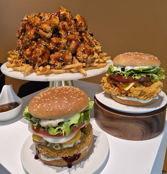 지난 3일 서울 중구 맘스터치 R&D 센터에서 열린 후덕죽 셰프와의 협업 신메뉴 시식회에서 △후덕죽 빅싸이순살 △후덕죽 싸이버거 △후덕죽 통새우버거(사진 왼쪽 위부터 시계방향)가 진열되어 있다. 김동환 기자