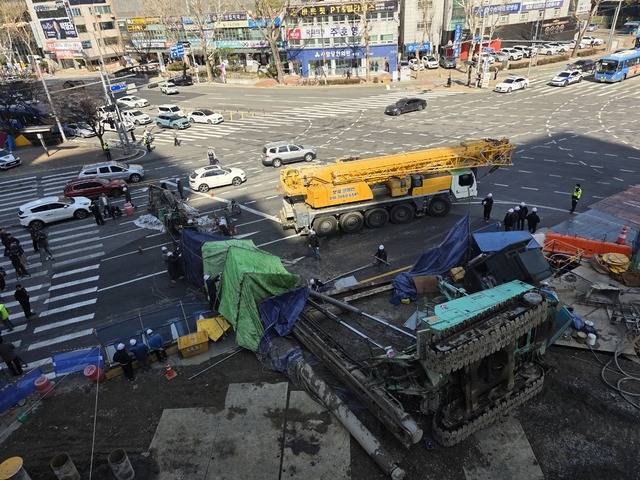 지난 4일 대구 수성구 만촌동 도시철도 2호선 만촌역 지하연결통로 건설공사 현장에서 대형 천공기가 쓰러져 도로를 덮치자, 관계자들이 장비를 해체하는 등 현장을 수습하고 있다. 김용국 기자