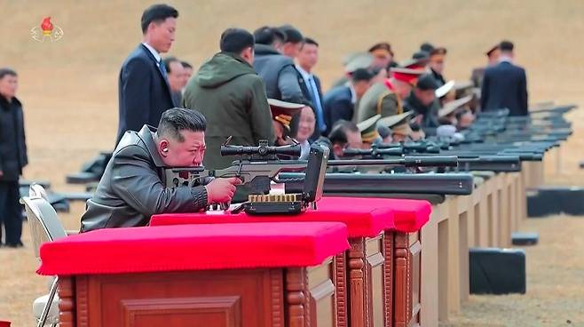 김정은이 지난달 27일 당중앙위원회 본부에서 주요 지도간부들과 군사지휘관들을 만나 신형저격수보총을 선물한 뒤 지도간부들과 사격장에서 저격무기사격을 하고 있다. 조선중앙TV