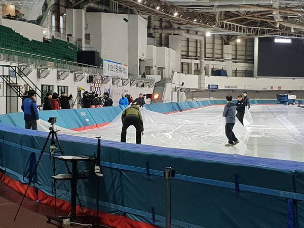 지난 2019년 2월 서울 태릉국제스케이트장에서 천장 누수가 발생하자 관계자들이 빙상 트랙에 비닐을 덮고 있다. 연합뉴스