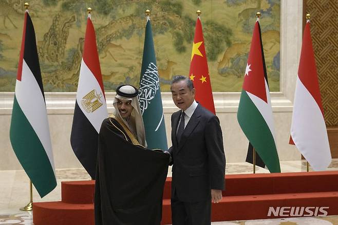 [베이징=AP/뉴시스] ﻿﻿왕이 중국공산당 정치국 위원 겸 외교부장이 이란의 공격을 받고 있는 걸프국 외교장관들과 잇따라 통화하며 중동 특사 파견 계획을 밝혔다. 사진은 왕 부장이 베이징에서 파이살 장관과 악수하는 모습. 2026.03.05