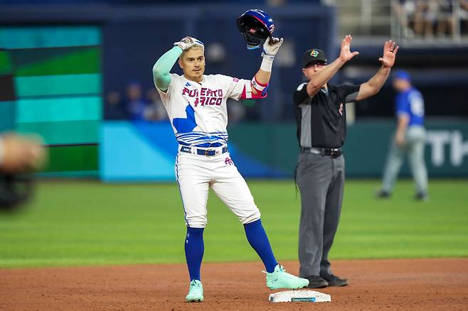 푸에르토리코 엔리케 에르난데스가 2023 WBC 이스라엘전에서 2루타를 친 뒤 베이스에서 헬멧을 들어보이고 있다. Getty Images코리아
