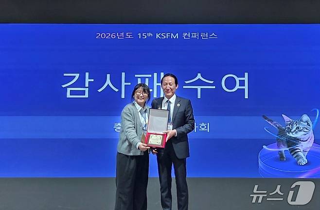 이승근 충북수의사회장이 서울 세종대에서 장효미 KSFM 이사에게 감사패를 전달하고 있다. ⓒ 뉴스1