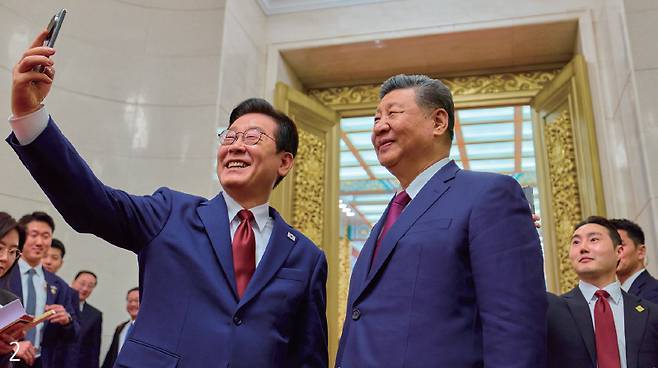 2. 이재명 대통령이 시진핑 중국 국가주석과 1월 5일 베이징 인민대회당에서 2025년 11월 경주 정상회담 때 선물 받은 스마트폰으로 기념 촬영하고 있다. /공동 취재단