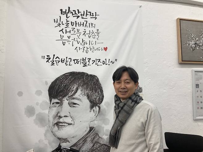 ‘인쇄 분야 서울 명장’ 김인호 동양상사지기인쇄 대표가 아들이 칠순 기념으로 선물한 응원 현수막 앞에서 웃고 있다. 손인규 기자