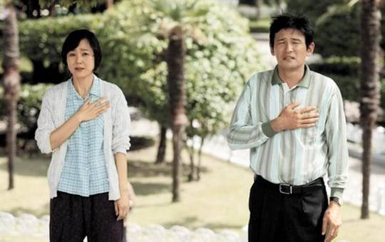 역대 관객 수 2위의 영화 '국제시장'의 한 장면. 부부싸움을 하다가도 애국가가 울리자 '국기에 대한 경례'를 올리는 산업화 시대 부모들의 모습이다. 올해 '국제시장2'가 12년만에 나올 예정이다. /CJ ENM