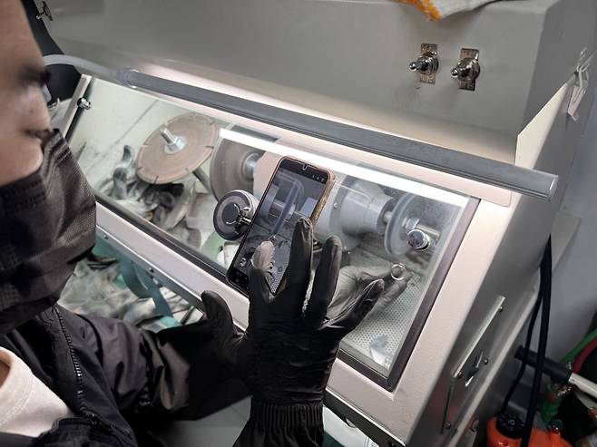 폴리싱 기계에서 반지의 광을 내고 있는 모습을 영상으로 찍고 있다. 영상은 숏폼에 필요한만큼 아주 짧게 찍고 다시 작업에 집중한다. 백재연 기자