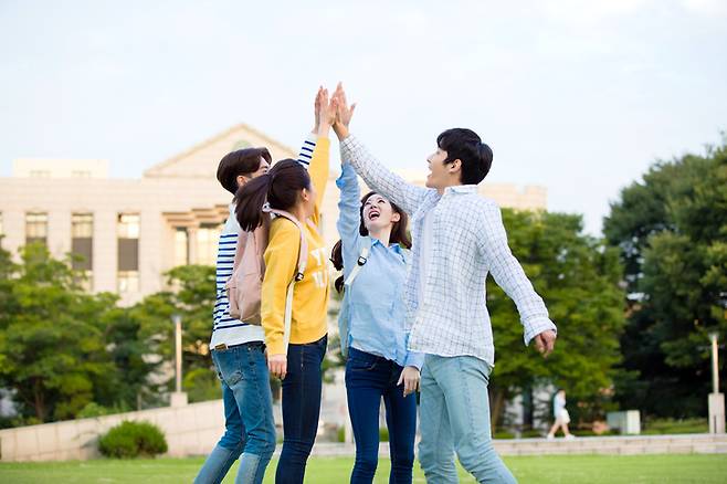 새 봄을 밪아 대학생들이 캠퍼스에서 하이파이브를 하고 있다.  '키스병'으로 불리는 전염성 단핵구증은 엡스타인-바 바이러스(EBV)에 의해 감염되며 보통 심한 목 통증(인후통)을 동반한다. 사진=게티이미지뱅크