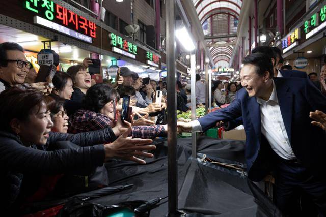2024년 10월 윤석열 당시 대통령이 부산역 인근 전통시장인 초량시장을 방문해 시장을 찾은 시민과 상인들을 응원하고 격려하고 있다. 연합뉴스 자료사진