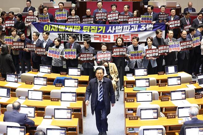 지난달 27일 국회에서 열린 2월 임시국회 8차 본회의에서 전날 상정된 '재판소원법'에 대한 무제한 토론 종결을 위한 투표가 시작되자 국민의힘 의원들이 손팻말과 피켓을 들고 시위를 펼치는 가운데 민주당 정청래 대표가 우원식 국회의장에게 항의한 뒤 국민의힘 의원들을 지나쳐 이동하고 있다. /사진=연합뉴
