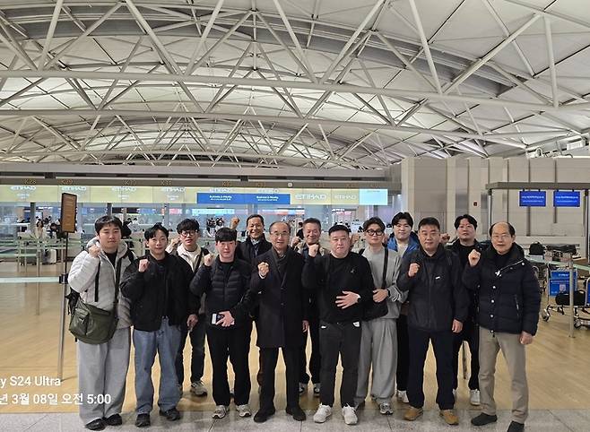 8일 정석현 수산그룹 회장(왼쪽에서 넷째) 등 수산그룹 임직원들이 인천국제공항에서 주먹을 불끈 쥐며 기념촬영을 하고 있다. 수산그룹 엔지니어 11명은 바라카 원전의 계획예방정비 공사를 사전 준비하기 위해 현지로 향했다. [사진제공=수산그룹]