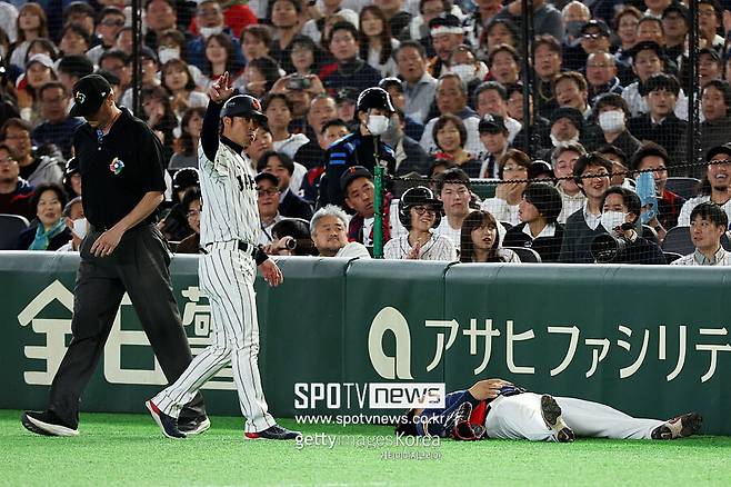 ▲ 7일 열린 2026 WBC 한국과 일본의 경기에서 한국 1루수 문보경이 수비 도중 담장에 부딪혀 쓰러지자 일본 가메이 요시유키 1루 코치(왼쪽)가 한국 트레이너를 부르고 있다.