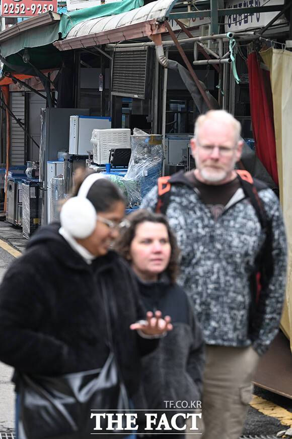 황학동 만물시장에서 시계를 구매하고 손목을 바라보는 외국인 관광객.