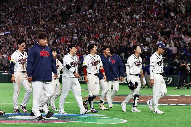 한국 야구가 8일 일본 도쿄돔에서 열린 WBC 대만과의 C조 3차전에서 4-5로 졌다. 승리를 자축하는 대만 선수들(위 사진)과 침울한 표정으로 경기장을 빠져나가는 한국 선수단의 모습이 극명하게 대비된다. [AP=연합뉴스, 뉴스1]