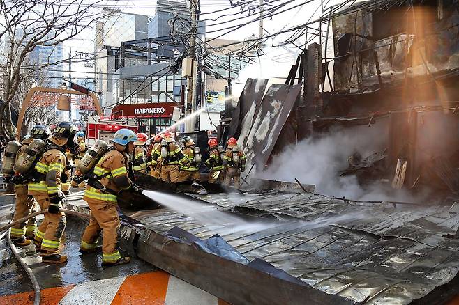 지난 2월 9일 대구 중구 종로의 한 음식점 건물에서 원인을 알 수 없는 불이 나 출동한 소방관들이 화재를 진압하기 위해 구조물을 뜯고 있다. 뉴스1