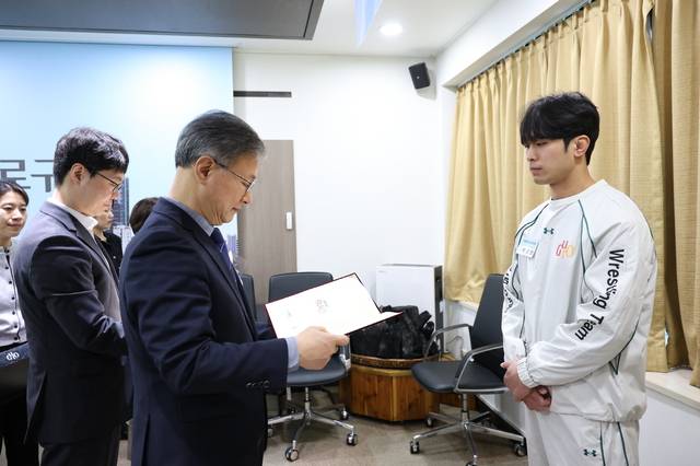 장인홍(가운데) 서울 구로구청장이 3월 6일 구청 르네상스홀에서 열린 ‘구로구청 직장운동경기부 신규 선수 입단식’에서 레슬링팀 박성민 선수에게 임용장을 수여하고 있다. 구로구청 제공