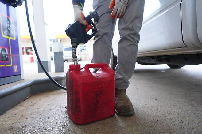 국제 유가가 폭등하는 가운데 9일(현지시간) 미국 텍사스주 알링턴의 주유소에서 한 남성이 휘발유를 통에 주유하고 있다. AP 뉴시스