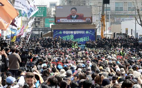 서울 종로구 헌법재판소 인근에 모인 시민들이 지난해 5월 4일 오후 윤석열 대통령 탄핵 심판 선고에 귀를 기울이고 있다. 김성룡 기자